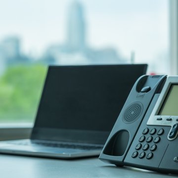 best voip service ringcentral voip phone on desk in office laptop in the background